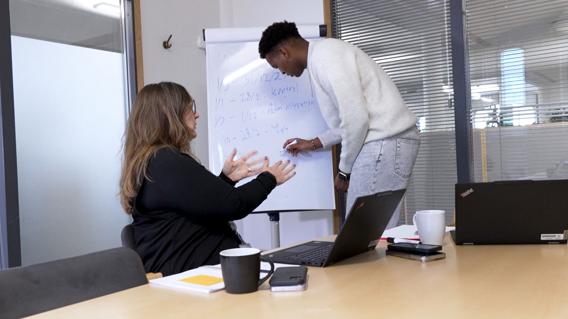 Elev og medarbejder har samtale i et kontorlokale